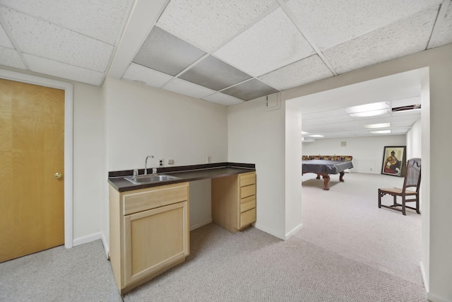 bar with a paneled ceiling, light carpet, a sink, and baseboards