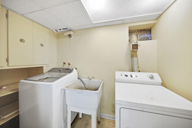 laundry area with cabinet space, baseboards, a sink, and independent washer and dryer