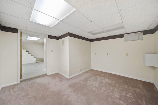 finished basement with baseboards, visible vents, a drop ceiling, stairway, and carpet