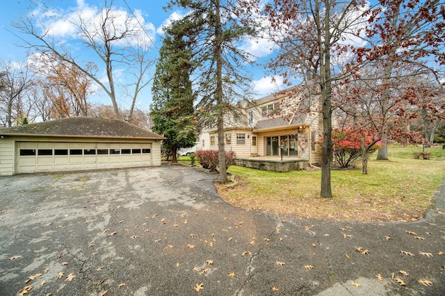 view of front of home with a garage, a front yard, and an outdoor structure