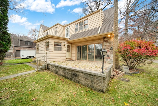 rear view of property with roof with shingles, a lawn, and a patio area