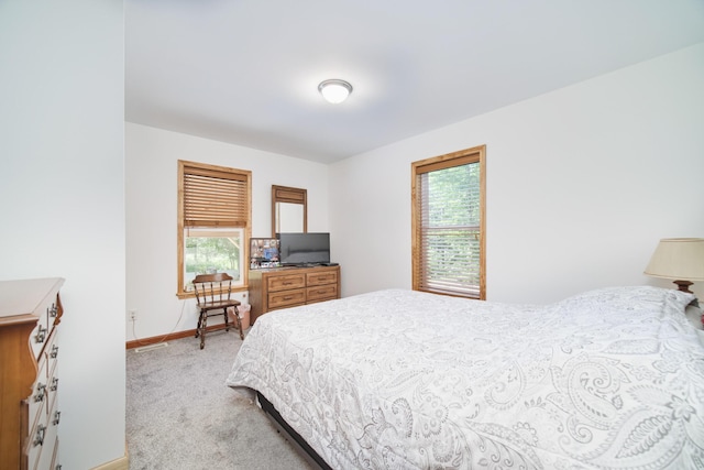 carpeted bedroom with multiple windows and baseboards