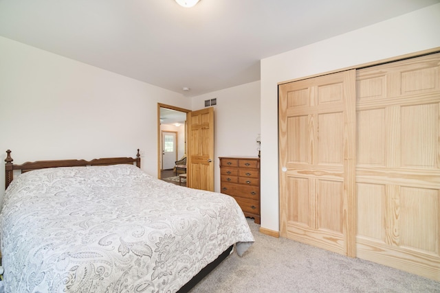 bedroom with light colored carpet, a closet, and visible vents