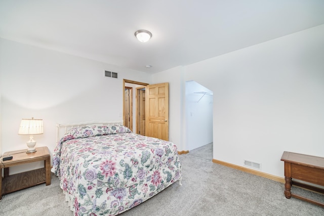 bedroom with baseboards, a spacious closet, visible vents, and carpet flooring