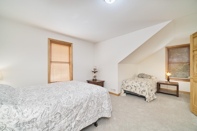 bedroom with baseboards and light colored carpet