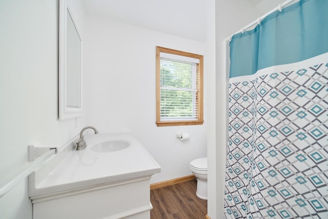 full bath featuring toilet, vanity, wood finished floors, a shower with curtain, and baseboards