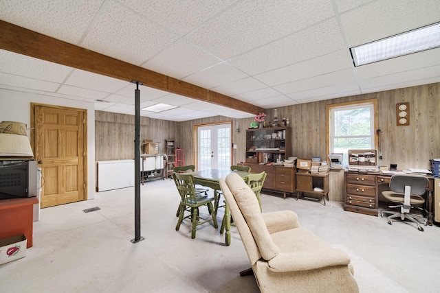 office featuring a paneled ceiling, french doors, and wood walls