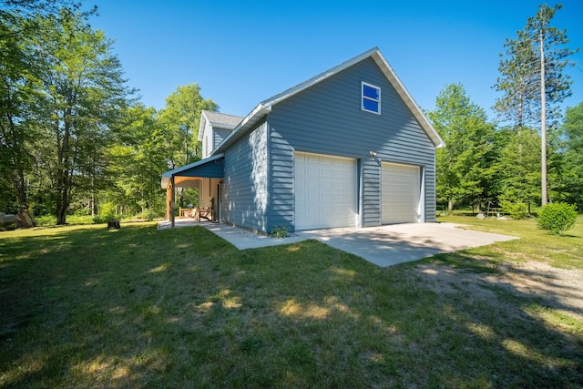 view of side of property featuring a garage, a yard, and driveway