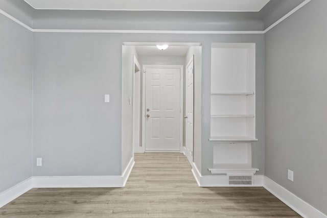 corridor with wood finished floors, visible vents, and baseboards