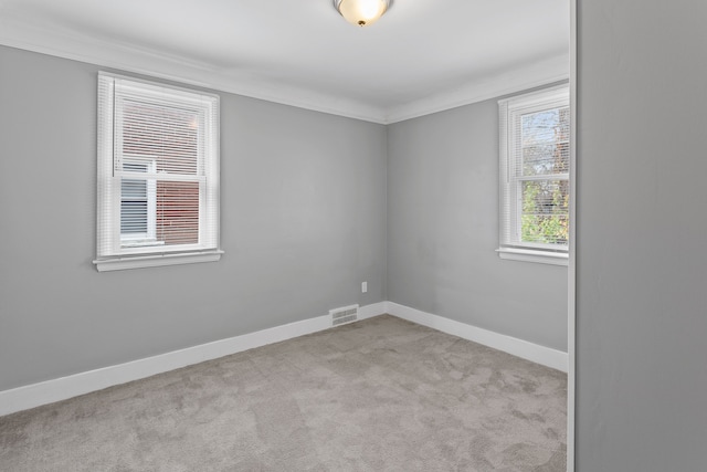 unfurnished room with baseboards, visible vents, carpet flooring, and ornamental molding