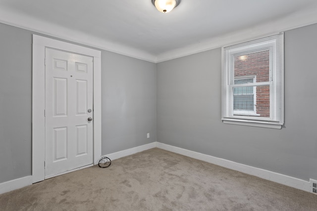 spare room featuring carpet flooring and baseboards