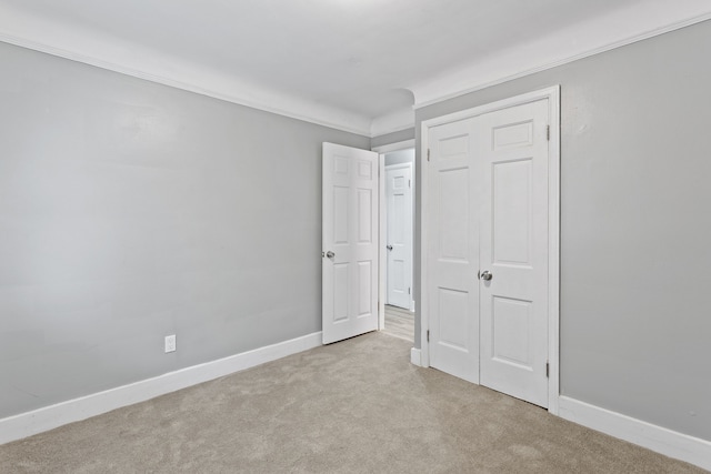 unfurnished bedroom featuring carpet floors, crown molding, and baseboards