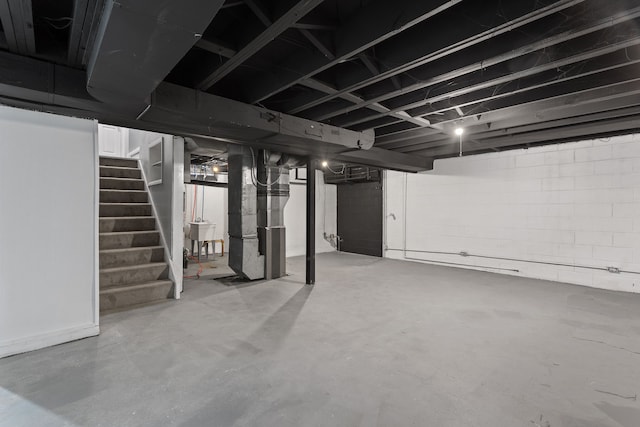 unfinished basement with stairs and heating unit