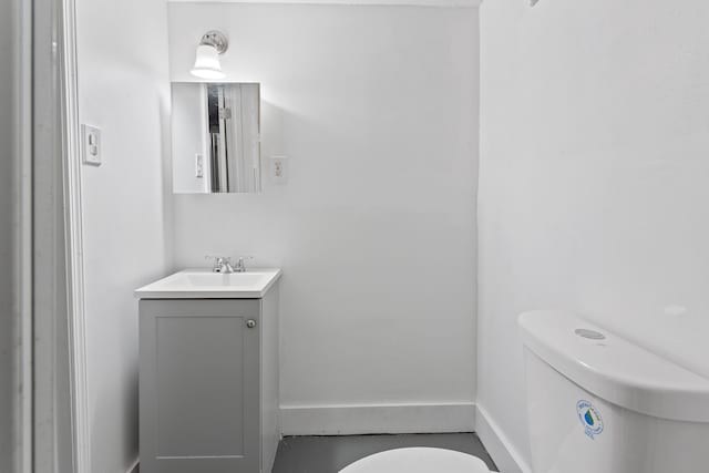 bathroom featuring vanity, toilet, and baseboards