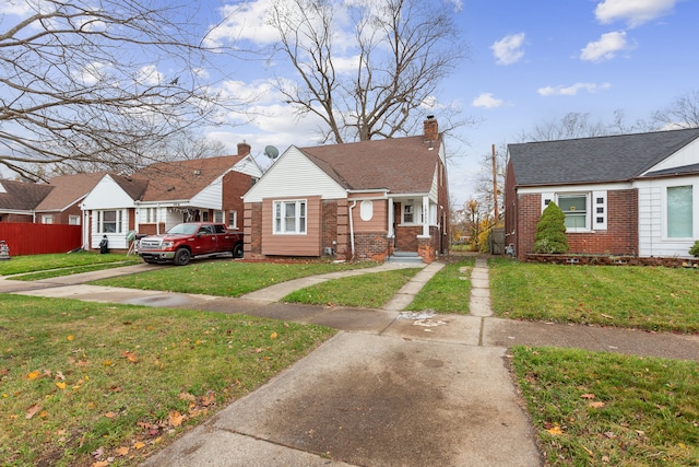 bungalow-style home with brick siding, a chimney, and a front lawn