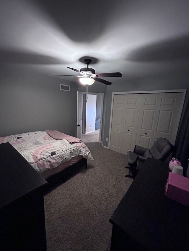 carpeted bedroom featuring ceiling fan, a closet, and visible vents