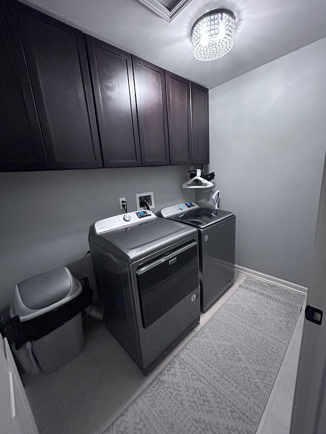 laundry area with baseboards, cabinet space, and washer and dryer