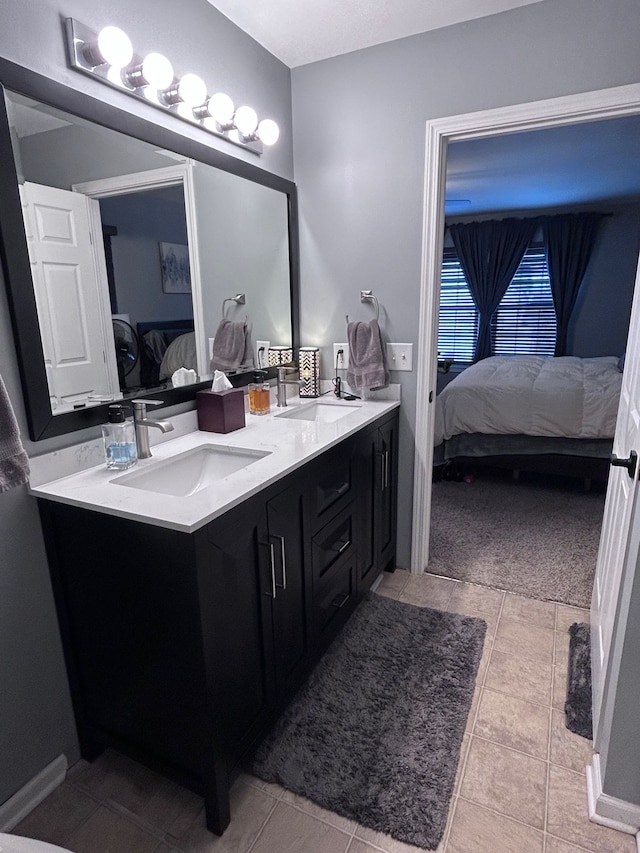 bathroom with tile patterned flooring, double vanity, a sink, and ensuite bathroom