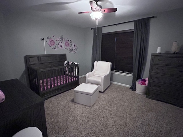 bedroom with carpet floors, a crib, baseboards, and a ceiling fan