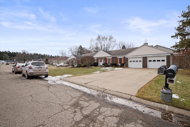 view of front of house with an attached garage, a front lawn, concrete driveway, and brick siding