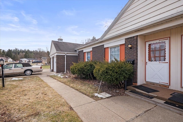 doorway to property with brick siding