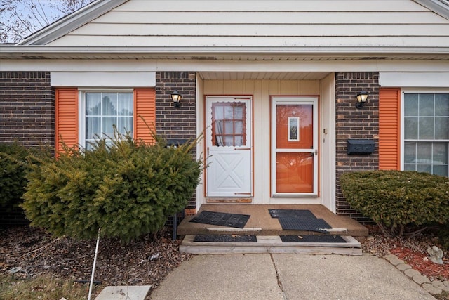 doorway to property featuring brick siding