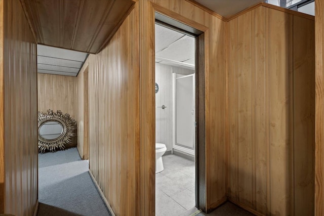 corridor with carpet flooring and wooden walls