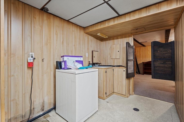 washroom with washer / clothes dryer, light carpet, and wooden walls