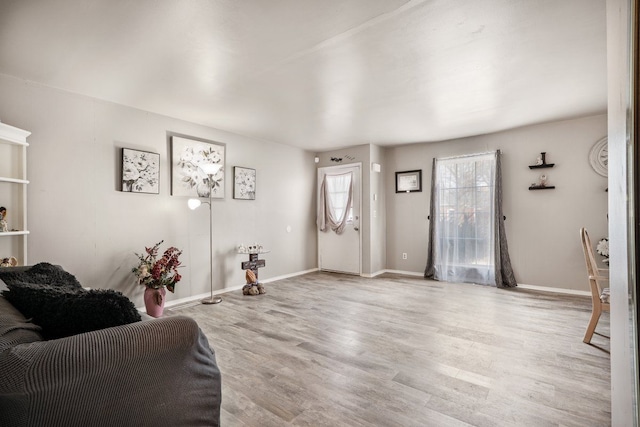 living area with light wood-style flooring and baseboards