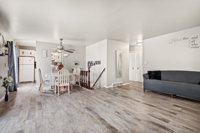 dining space with ceiling fan, light wood-type flooring, visible vents, and baseboards