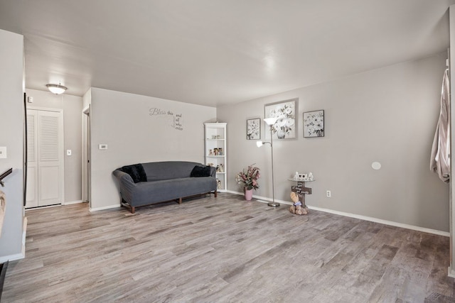 living area with light wood-type flooring and baseboards