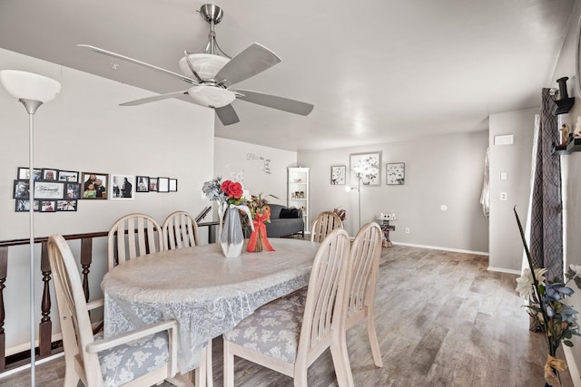 dining area with ceiling fan, baseboards, and wood finished floors