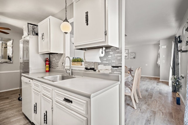 kitchen featuring a sink, white cabinetry, backsplash, and dishwasher