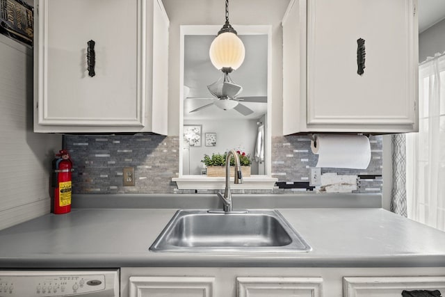 kitchen with tasteful backsplash, washer / clothes dryer, a ceiling fan, white cabinets, and a sink