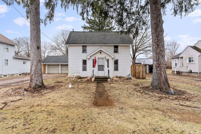 view of front of property with a garage, a shingled roof, and fence