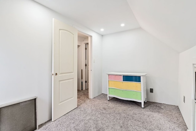 unfurnished bedroom with recessed lighting, vaulted ceiling, and light colored carpet