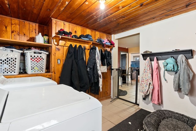 washroom with light tile patterned floors, wooden ceiling, laundry area, wood walls, and washer and dryer