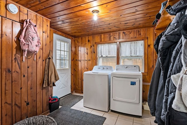 laundry room with light tile patterned floors, wood ceiling, wood walls, separate washer and dryer, and laundry area