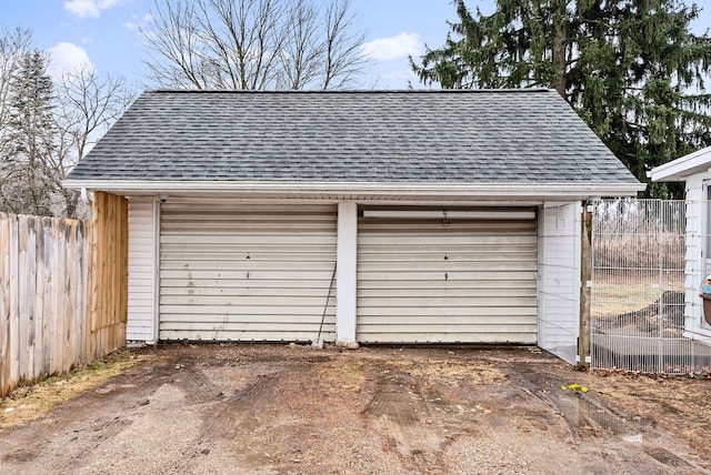 detached garage featuring fence