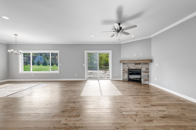 unfurnished living room with a wealth of natural light, a fireplace, ornamental molding, and wood finished floors