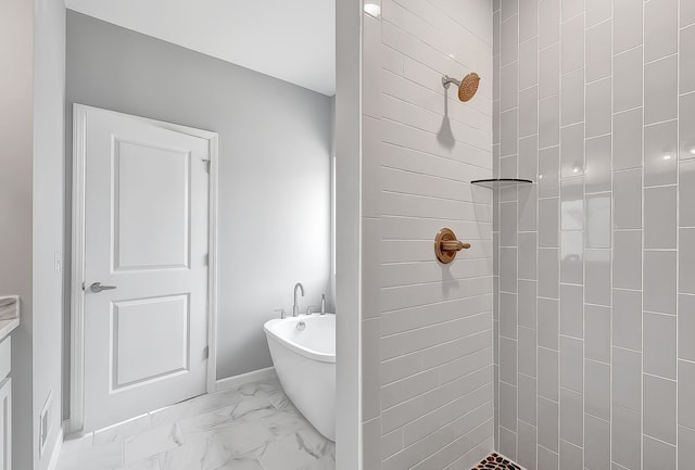 bathroom with marble finish floor, a freestanding bath, and tiled shower