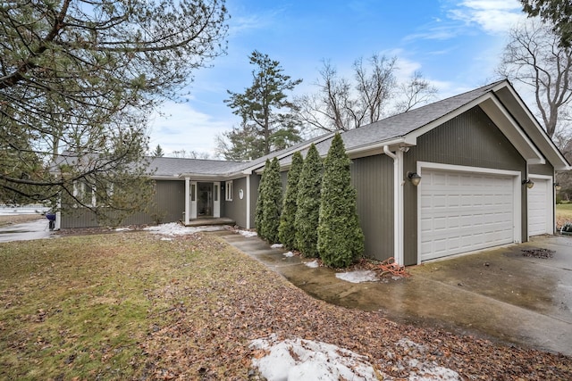 single story home featuring roof with shingles and an attached garage