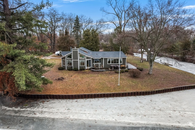 view of front of home featuring a sunroom and a chimney