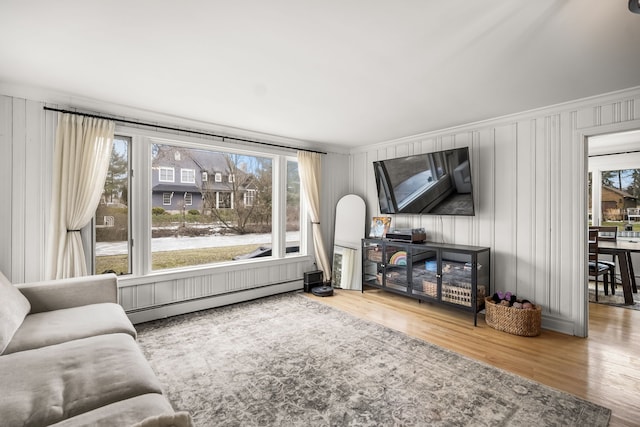 living room featuring a baseboard heating unit and wood finished floors