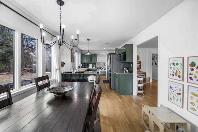 dining area with an inviting chandelier and light wood-style floors