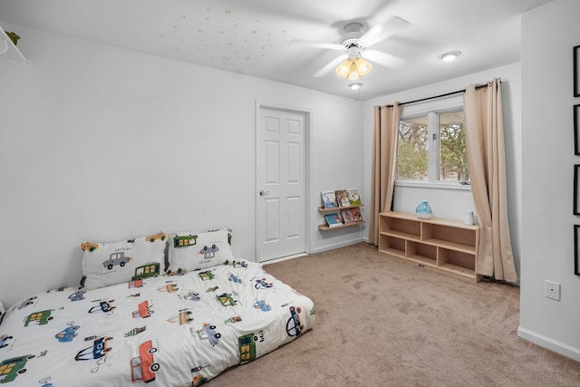 carpeted bedroom featuring a ceiling fan and baseboards