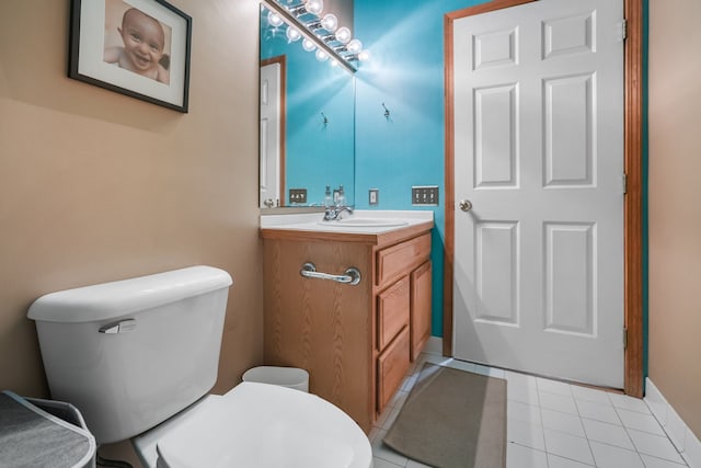 half bathroom with vanity, toilet, and tile patterned floors