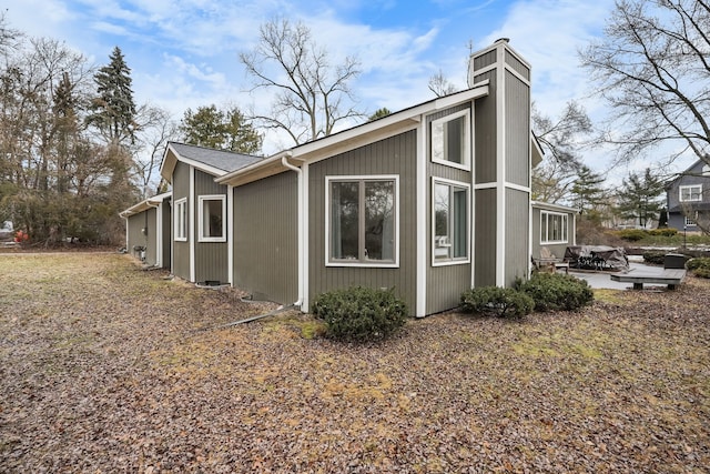 view of home's exterior with a patio and a chimney