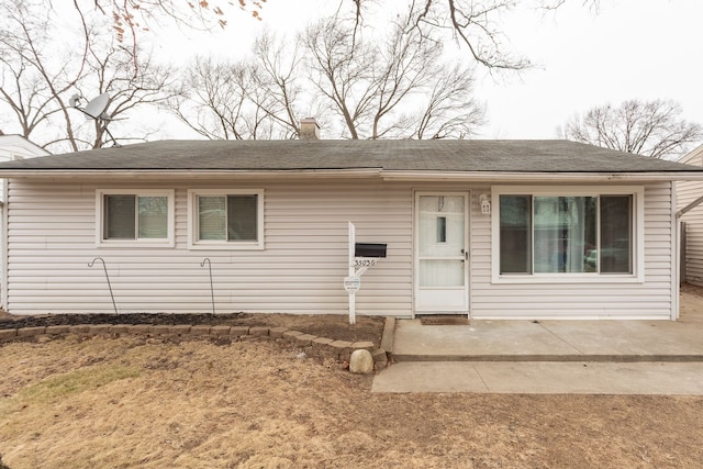 view of front of home with a patio area and a chimney