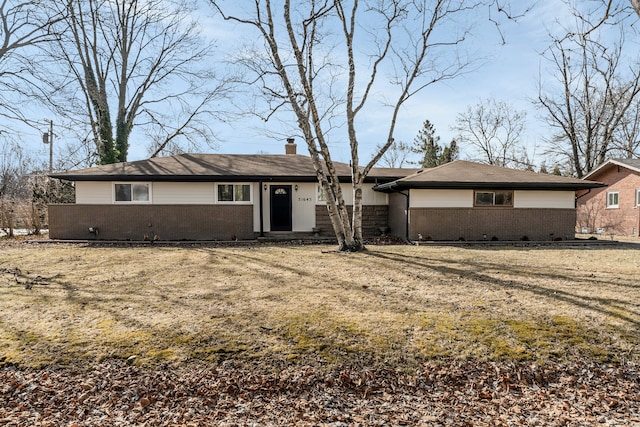 ranch-style house featuring a chimney and brick siding